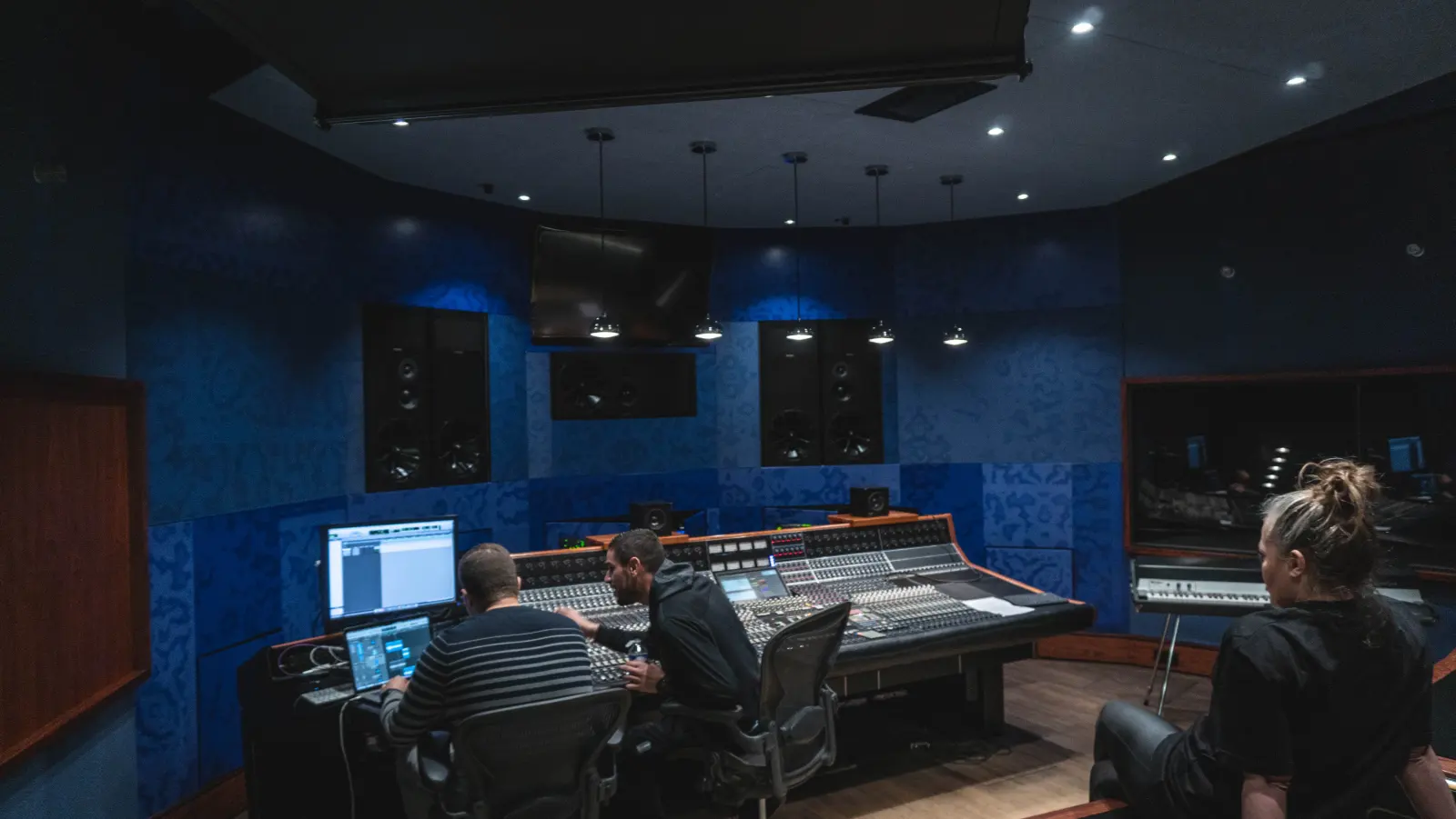Professional mixing and mastering engineer working at an analog mixing console